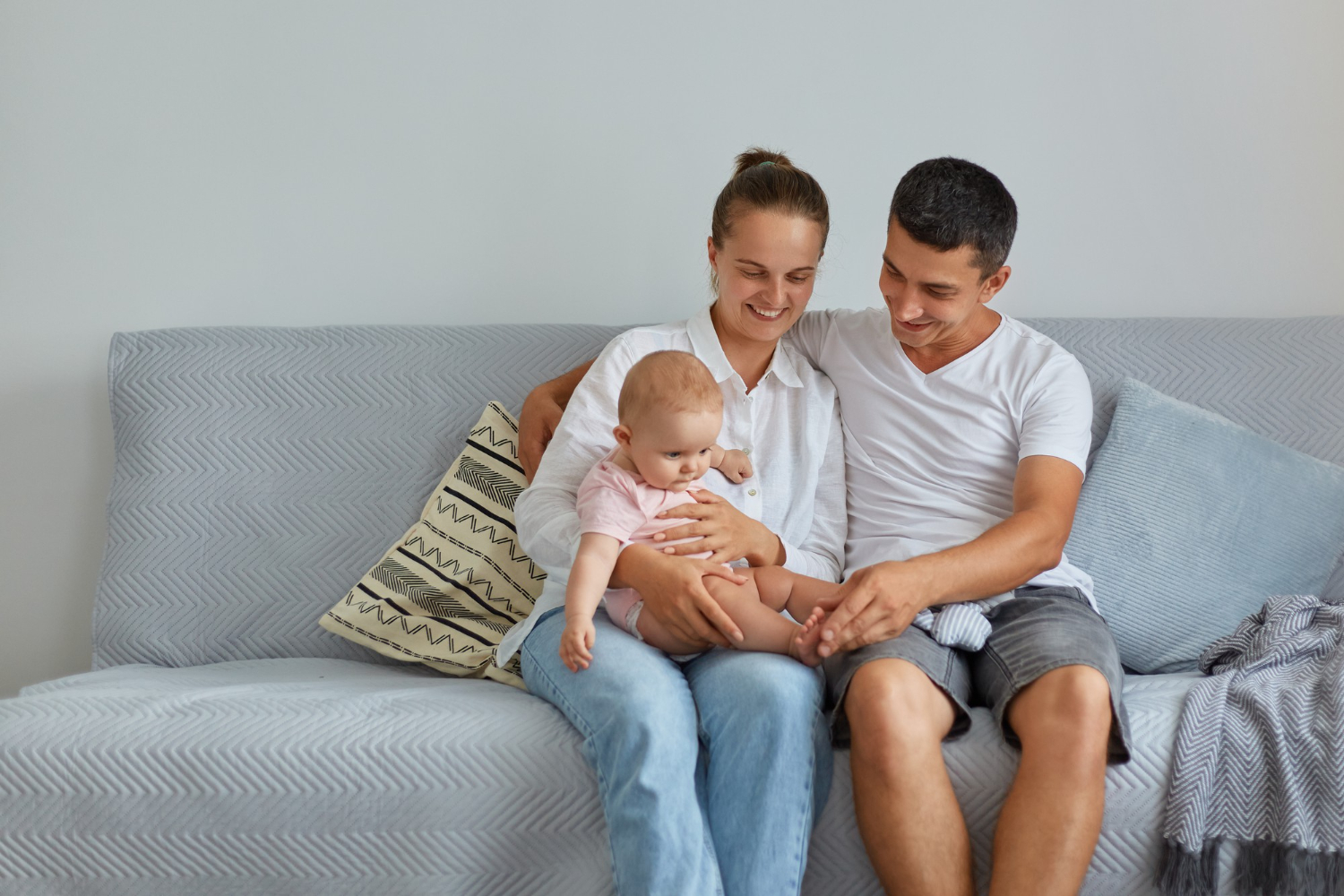 portrait-happy-family-sitting-sofa-living-room-people-wearing-casual-clothing-spending-time-with-their-infant-baby-home-parenthood-childhood